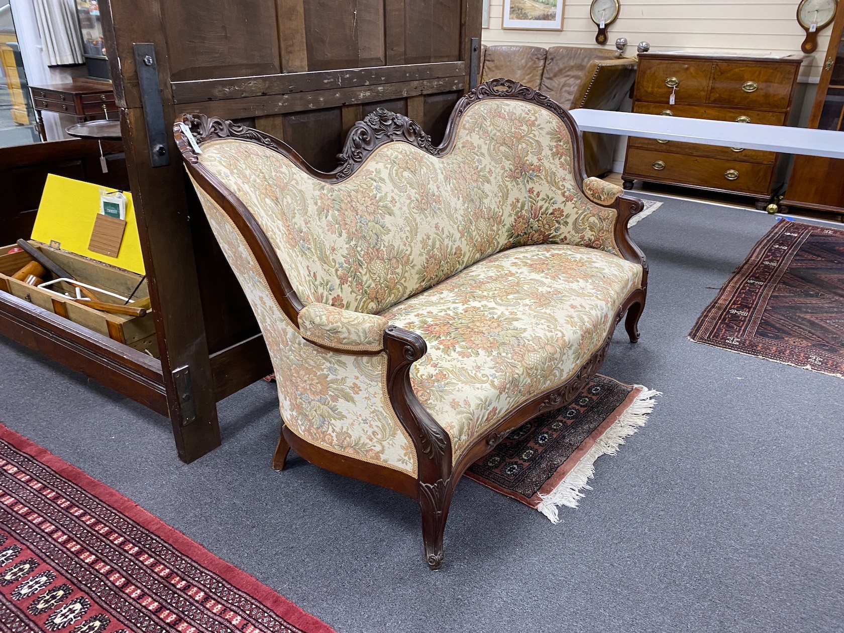 A Victorian upholstered carved mahogany double spoonback settee, width 176cm, depth 74cm, height 99cm